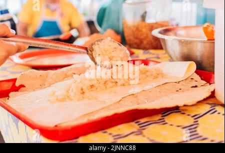 Vista sul tradizionale Quesillo con cipolla sottaceto, preparazione del Quesillo tradizionale Nicaraguano. Mani fare delizioso Nicaraguan Quesillo. Foto Stock