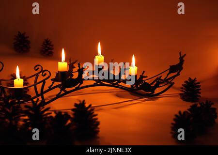 Quattro candele rosse dell'avvento con quattro candele accese e decorazione  di natale che giace nella neve come modello Foto stock - Alamy