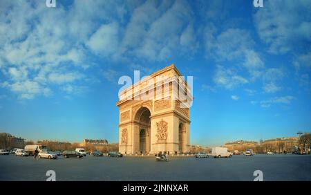 Il famoso Arco di Trionfo si erge in modo impressionante sopra Place Charles de Gaulle nel centro di Parigi, circondato dal traffico, catturato in una giornata di sole. Foto Stock