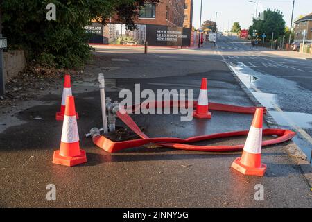 Slough, Berkshire, Regno Unito. 13th agosto, 2022. Un motore antincendio aspira l'acqua da un idrante. Il Royal Berkshire Fire and Rescue Service stavate mettendo fuori un fuoco presso lo stabilimento di riciclaggio Simpson a Simpsons Way, Slough questa mattina dietro il Tempio di Ramgarhia Sikh. Ai residenti è stato consigliato di rimanere all'interno e tenere le finestre chiuse. Un camion Zetros che contiene 8.000 litri d'acqua è stato anche sulla scena per smorzare il fuoco. Credit: Maureen McLean/Alamy Live News Foto Stock