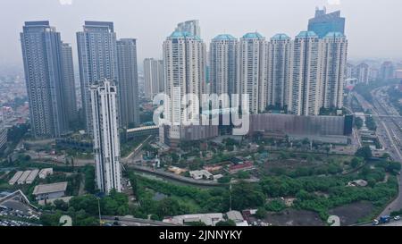 Confronto tra alti edifici moderni e alloggi per residenti irregolari situato a Giacarta, la capitale dell'Indonesia Foto Stock