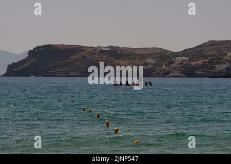 IOS, Grecia - 8 giugno 2021 : i giovani turisti con tavole di pagaia standup hanno formato un cerchio per parlare e riposare sulla spiaggia di Mylopotas in Grecia iOS Foto Stock