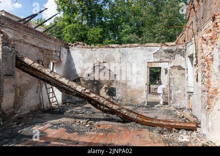 KHARKIV REG, UCRAINA - 30 luglio 2022: Un dipendente del Museo Skovoroda racconta come la casa del filosofo ucraino Hryhoriy Skovoroda Museum è stata distrutta da uno sciopero missilistico nella regione di Kharkiv Foto Stock