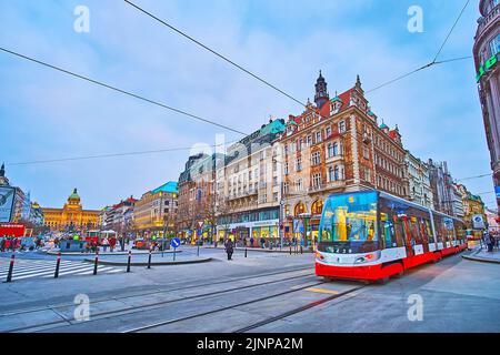 PRAGA, REPUBBLICA CECA - 6 MARZO 2022: Il tram moderno, a cavallo lungo la Piazza Venceslao sera con vista sulla casa di Wiehl affrescata e sul Museo Nazionale Foto Stock