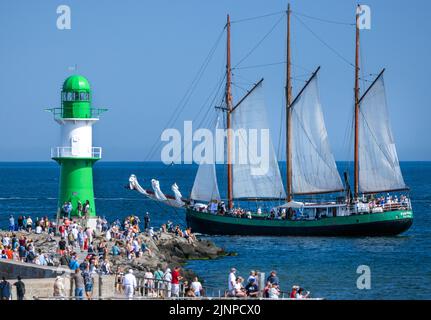 Rostock, Germania. 13th ago, 2022. La goletta tedesca 'Pippilotta' naviga oltre il molo fino al Mar Baltico per un viaggio all'interno della Hanse Sail. Dopo la cancellazione nel 2020 a causa della corona e della più piccola edizione giubilare dello scorso anno, la Hanse Sail è ancora una volta il più grande festival di folklore marittimo nel Meclemburgo-Pomerania occidentale quest'anno con 111 navi tradizionali e centinaia di migliaia di visitatori attesi. Credit: Jens Büttner/dpa/Alamy Live News Foto Stock