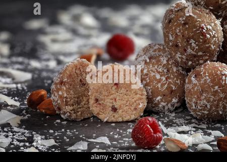 Home caramelle con lampone sublimato e patatine di cocco su sfondo grigio. Foto per menu o pubblicità dolciaria Foto Stock