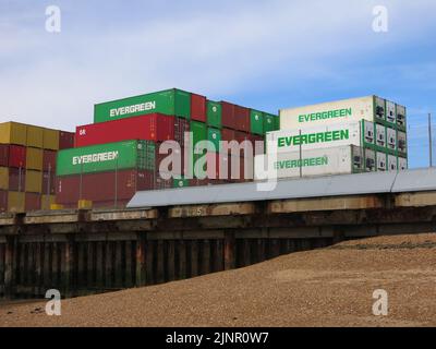 Contenitori per spedizioni Evergreen impilati sul molo del porto di Felixstowe, il terminal più trafficato del Regno Unito per il trasporto merci containerizzato. Foto Stock