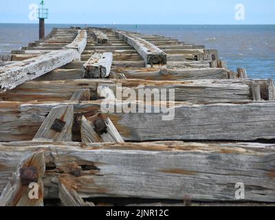 Utilizzati per il trasporto di miniere di mare per difendere Harwich Harbour, le vecchie tavole di legno sono tutto ciò che resta del molo ferroviario a Landguard Point, Felixstowe. Foto Stock