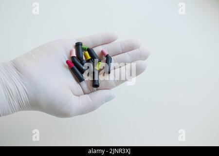 Tubi con denti materiali di riempimento compositi nelle mani del dentista Foto Stock