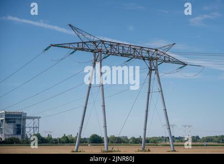 piloni e cavi trasportano elettricità da una centrale nucleare in campagna Foto Stock