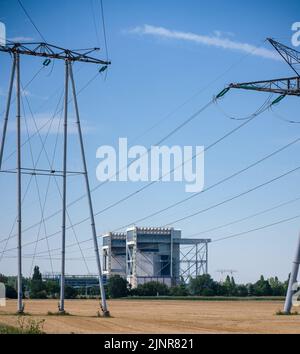 piloni e cavi trasportano elettricità da una centrale nucleare in campagna Foto Stock