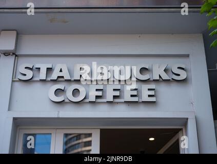 Basilea, Svizzera - Luglio 4 2022: Logo Starbucks esposto sulla facciata di un negozio Starbuks. Starbucks è una catena multinazionale americana di coffeeho Foto Stock