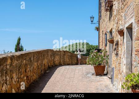 Un turista solita lungo la passerella sopra le mura di Pienza, Toscana Foto Stock