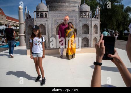 Mosca, Russia. 13th agosto 2022. I visitatori vengono fotografati sullo sfondo di un banner con l'immagine del Taj Mahal durante il festival India Day che si svolge nel Dream Island Park di Mosca, Russia Foto Stock