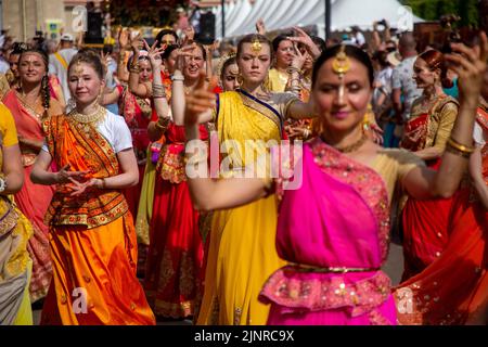 Mosca, Russia. 13th agosto 2022. Le donne russe in costumi nazionali indiani cantano 'Hare Krishna' e ballano alla testa della processione della parata di Ratha Yatra, o del Chariot Festival religioso indù, come parte del festival India Day che si svolge nel Dream Island Park di Mosca, Russia Foto Stock