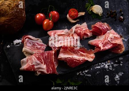 Fette di prosciutto iberico su una fetta di pane tostato Foto Stock