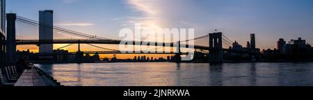 Panoramica di Silloutte del Brooklyng Bridge nelle prime ore del mattino dal molo con cielo limpido Foto Stock