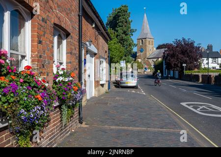 Church Street ad Alton, Hampshire, Inghilterra, Regno Unito, durante l'estate con vista sulla chiesa di San Lorenzo Foto Stock