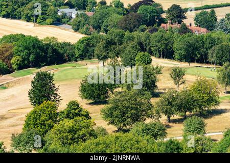 Butlers Cross, Buckinghamshire, Regno Unito. 13th agosto, 2022. Ellesborough Golf Club, vista sopraelevata che mostra green ben innaffiati e inzuppati che si contrappone all'erba arata altrove. I golfisti sul lato destro sfidano il calore estremo per giocare a golf. Credit: Stephen Bell/Alamy Live News Foto Stock