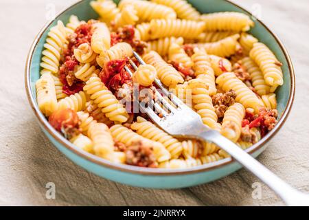 Pasta bolognese in piatto blu su sfondo luminoso. Piatto italiano tradizionale Foto Stock