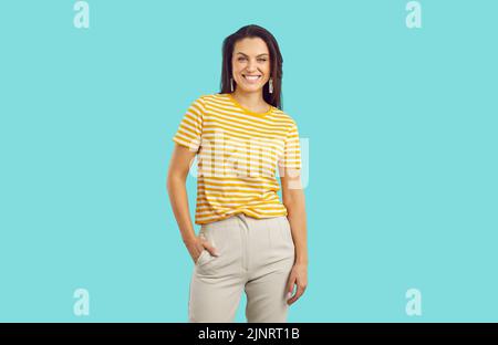 Ritratto di bella donna felice millenario in abiti casual isolato su sfondo turchese. Foto Stock