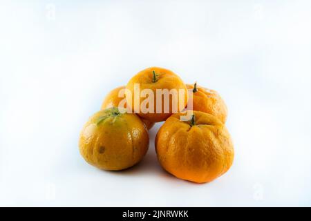 Superficie ricoperta da cinque tangerini freschi e succosi maturi, composizione isolata su fondo bianco. Foto Stock