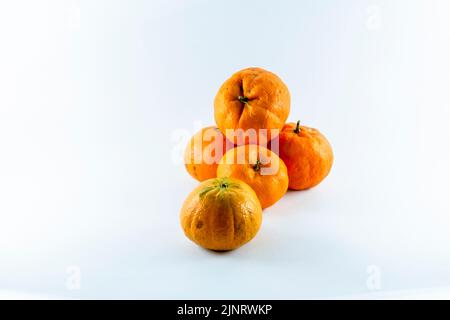 Superficie ricoperta da cinque tangerini freschi e succosi maturi, composizione isolata su fondo bianco. Foto Stock