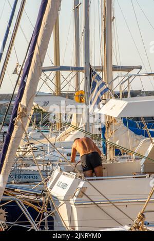 uomo che lavora sulla sua barca in una marina a cowes durante la settimana annuale cowes yachting regata sull'isola di wight uk, lavorando su barca, marina, mantenere Foto Stock