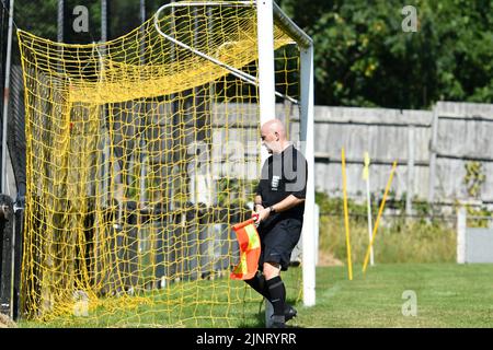 Un assistente arbitro (linesman) controlla la rete prima di una partita di calcio tra New Mills e Maine Road nella North-West Counties League. Foto Stock
