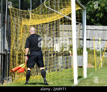 Un assistente arbitro (linesman) controlla la rete prima di una partita di calcio tra New Mills e Maine Road nella North-West Counties League. Foto Stock