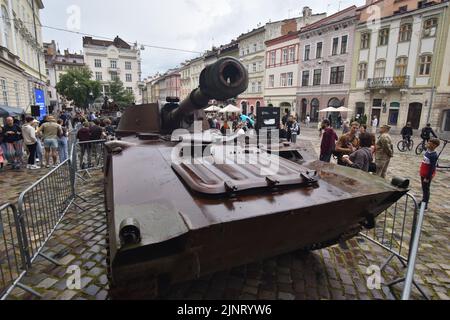 La gente guarda un impianto di artiglieria semovente russa in una mostra di attrezzature russe distrutte a Lviv. Organizzata dal governo ucraino, questa mostra sarà nel centro di Lviv fino alla fine dell'estate. Poi sarà trasferito nei paesi del Nord America. L'idea è quella di esporre i crimini che gli occupanti russi hanno commesso sul territorio ucraino. Foto Stock