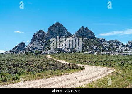 Una strada sterrata conduce a affioramenti di granito presso la City of Rocks National Reserve in Idaho, USA Foto Stock