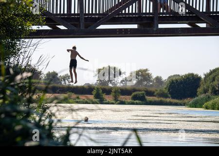 Dorney, Buckinghamshire, Regno Unito. 12th agosto, 2022. Giovani lapidazione da un ponte sul fiume Jubilee a Dorney in un'altra giornata calda e spaventosa. Credit: Maureen McLean/Alamy Live News Foto Stock