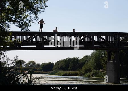 Dorney, Buckinghamshire, Regno Unito. 12th agosto, 2022. Giovani lapidazione da un ponte sul fiume Jubilee a Dorney in un'altra giornata calda e spaventosa. Credit: Maureen McLean/Alamy Live News Foto Stock