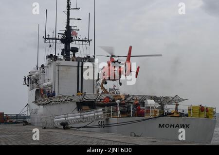 Un elicottero MH-65 Dolphin dalla stazione aerea della Guardia Costiera di Houston atterra sul ponte di volo dell'USCGC Mohawk (WMEC 913), mentre è ormeggiato ad Abidjan, Cotê d'Avorio, 12 agosto 2022. Mohawk è in fase di implementazione pianificata nell'area operativa delle forze navali statunitensi in Africa, impiegata dalla U.S. Sesta flotta per difendere gli interessi degli Stati Uniti, degli alleati e dei partner. (STATI UNITI Guardia costiera foto di Petty Officer 3rd Classe Jessica Fontenette) Foto Stock