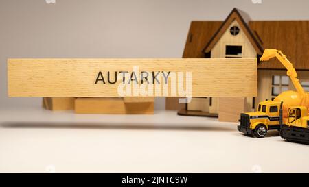 La parola autarky è scritta sulla superficie di legno. Concetto di casa e costruzione in background . Ipoteca ed economia Foto Stock