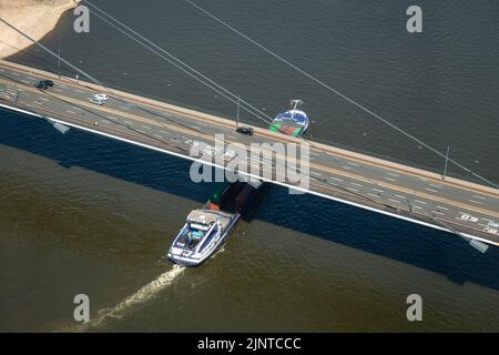 Düsseldorf, NRW, Germania. 13th ago, 2022. Una nave passa sotto il ponte di Rheinkniebrücke. Il fiume Reno, una delle vie navigabili interne più trafficate del mondo, è stato fortemente colpito dalla siccità che si è protratta e dai bassi livelli d'acqua, causati da un calore prolungato fino a 40 gradi e da una pioggia minima nelle ultime settimane. La corsia di navigazione si è notevolmente ridotta, rallentando il traffico, anche la maggior parte delle navi ha dovuto ridurre considerevolmente il peso del loro trasporto, causando problemi di approvvigionamento e prezzi di spedizione più elevati. Credit: Imageplotter/Alamy Live News Foto Stock