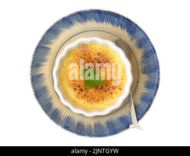 Crème brulee in una ciotola di ceramica isolata su fondo bianco Foto Stock