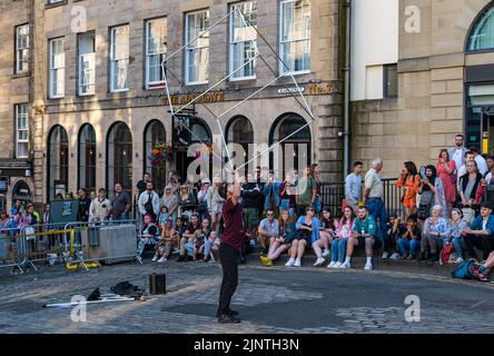 Edimburgo, Scozia, Regno Unito, 13th agosto 2022. Intrattenimento Edinburgh Fringe: Un artista di strada intrattiene la folla con un atto di equilibrio Foto Stock