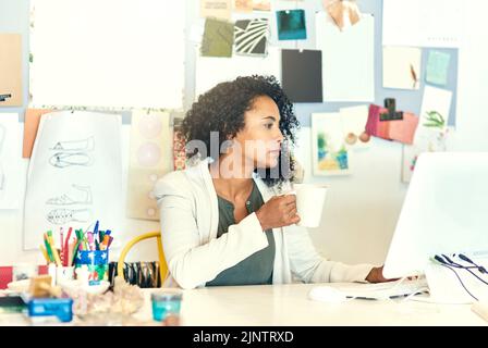 Sempre al passo con le tendenze e le mode attuali. Un designer che lavora al suo computer nel suo ufficio. Foto Stock