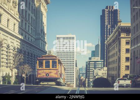 SAN FRANCISCO, USA - 12 febbraio 2018: Funivia che attraversa Mason e Taylor Street, centro di San Francisco, Bay Bridge sullo sfondo Foto Stock