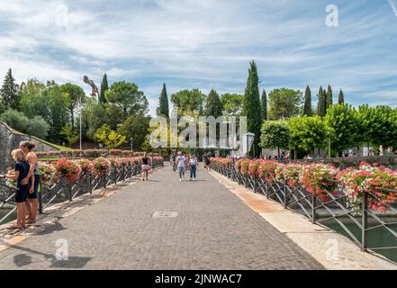 Turisti sul ponte della città di Peschiera del Garda, lago di Garda, provincia di Verona, Veneto, regione del nord Italia. Incantevole cittadella fortificata Foto Stock