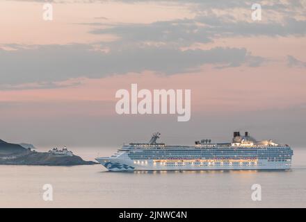 Porto di Cork, Cork, Irlanda. 14th agosto, 2022. La nave da crociera Island Princess sta per raggiungere il faro di Roches Point all'alba in una fresca mattinata estiva mentre si recava per una visita a Cobh, Co. Cork, Irlanda. - Immagine David Creedon Foto Stock