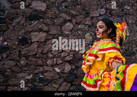 Una ragazza messicana, vestita come la Catrina, icona della cultura pop messicana, danza durante le celebrazioni del giorno dei morti a Taxco, Messico. Foto Stock