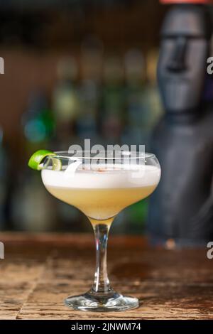 Cocktail Pisco Sour al bar. Sfondo sfocato. Peruviano, messicano, cileno tradizionale bevanda pisco sour liquore con lime e uova. Foto Stock