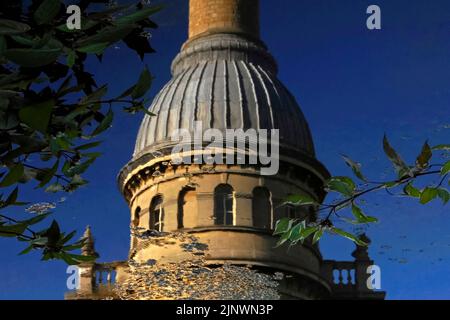 Le increspature si diffondono sulla superficie del lago prima dell'ex Bliss Tweed Mill di Chipping Norton, Oxfordshire, Inghilterra, Regno Unito, offuscando le linee della sua torre dell'orologio circolare, ricoperta da una caratteristica cupola rivestita di piombo e da un'elegante ciminiera. Il mulino è stato chiuso nel 1980 ma ora è diviso in appartamenti di lusso. Foto Stock