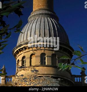 Increspature che si propagano attraverso la superficie del lago prima dell'ex Bliss Tweed Mill a Chipping Norton, Oxfordshire, Inghilterra, Regno Unito, offuscando le linee della sua torre dell'orologio circolare, tappata da una caratteristica cupola rivestita in piombo e un'elegante ciminiera. Il mulino è stato chiuso nel 1980 ma ora è diviso in appartamenti di lusso. Foto Stock