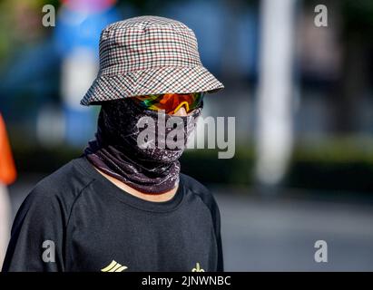 Fuyang, Cina. 14th ago, 2022. Una donna indossa una maschera di protezione solare, una visiera e occhiali da sole verso i forti raggi ultravioletti. L'Osservatorio Meteorologico Centrale della Cina ha emesso un avvertimento rosso ad alta temperatura. Si prevede che la temperatura massima in alcune parti della Cina raggiungerà oltre i 40 ? Il 14 agosto. Credit: SOPA Images Limited/Alamy Live News Foto Stock