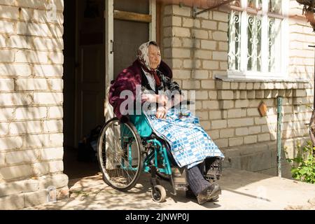 Donna anziana seduta su una sedia a rotelle che sembra triste e preoccupato: Depressione, assistenza sanitaria e cura per gli anziani Foto Stock