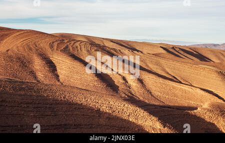 Panorama delle colline con regolare modello di terreno marrone in Tizi'n-Tinififft passo Ouaourmas Marocco, cielo blu sopra Foto Stock